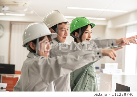 ヘルメットを着用して指さし呼称する男女3人のエンジニア ヘルメットを着用して指さし呼称する男女3人のエンジニア 111229740