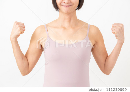 腕の筋肉を見せるキャミソール姿のミドル女性 111230099