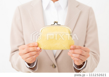 黄色のがま口財布を持つスーツ姿のミドル女性 111232021