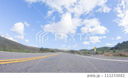 On a clear winter day, a car smoothly travels along Highway 101 near Santa Maria, California, under a brilliant blue sky, surrounded by a blend of greenery and golden hues. On a clear winter day, a car smoothly travels along Highway 101 near Santa Maria, California, under a brilliant blue sky, surrounded by a blend of greenery and golden hues. 111233082