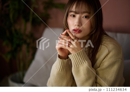 部屋でソファーに座る茶髪の女性 111234634