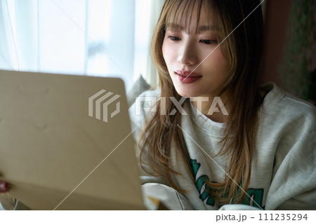 荷物を確認する若い女性 荷物を確認する若い女性 111235294