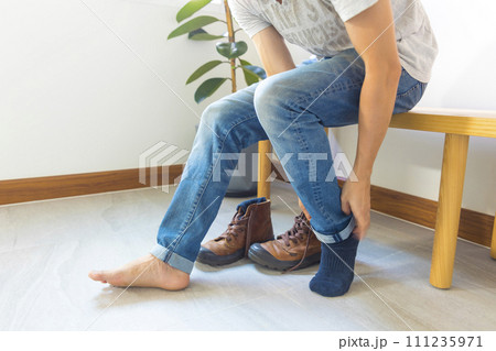 Young man sit and prepare puts on booty shoes Young man sit and prepare puts on booty shoes 111235971