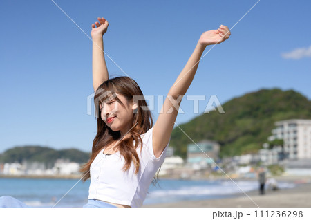 晴れの日の砂浜にたたずむ女性 晴れの日の砂浜にたたずむ女性 111236298