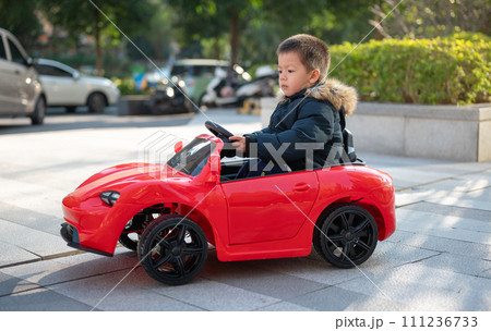 Adventurous Toddler Drives Red Sports Car with Joyful Glee 111236733