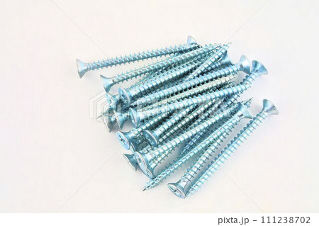 Screws for construction on a white background, metal screw, iron screw, chrome screw, screws as a background, wood screw. Close-up Screws for construction on a white background, metal screw, iron screw, chrome screw, screws as a background, wood screw. Close-up 111238702