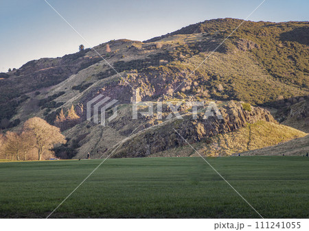 The breathtaking scenic landscape of Holyrood park with Salisbury Crags rugged hills and sky background. The breathtaking scenic landscape of Holyrood park with Salisbury Crags rugged hills and sky background. 111241055