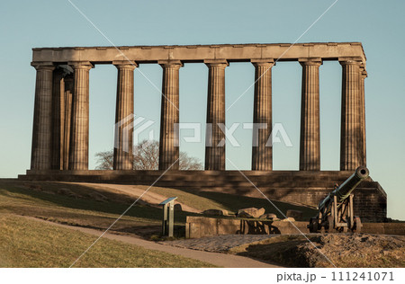 A view of the National Monument of Scotland with a bright blue sky in the background. 111241071