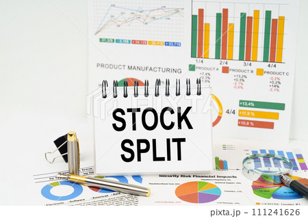 On the table are reports with graphs and a notepad with the inscription - Stock split On the table are reports with graphs and a notepad with the inscription - Stock split 111241626