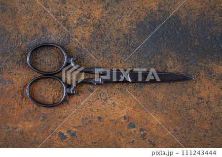 Vintage embroidery scissors on rusty background Vintage embroidery scissors on rusty background 111243444