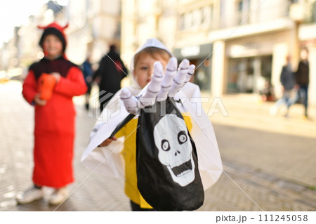 The kids dressed up in the city on Halloween asking for candy 111245058