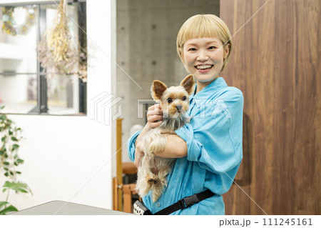 ドッグサロンでヨークシャーテリアを抱くショートヘアの女性 ドッグサロンでヨークシャーテリアを抱くショートヘアの女性 111245161