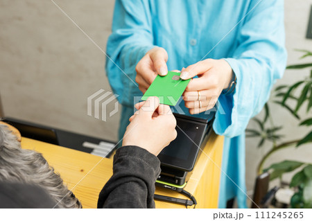 ドッグサロン,クレジットカードを返却する女性スタッフ 111245265