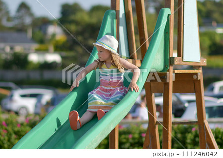 Girl of 3 years old sliding outdoor Playground 111246042