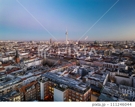 Aerial panoramic shot of apartment houses in Mitte district at twilight. Popular tall Fernsehturm in distance against clear sky. Berlin, Germany Aerial panoramic shot of apartment houses in Mitte district at twilight. Popular tall Fernsehturm in distance against clear sky. Berlin, Germany 111246044
