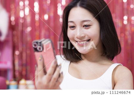 部屋でスマホを見る若い女性 部屋でスマホを見る若い女性 111246674