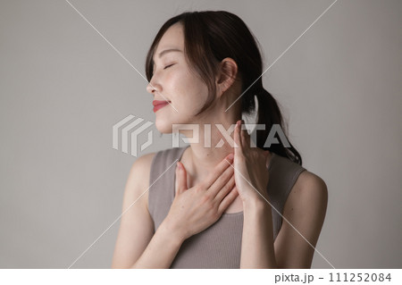 鎖骨を押さえる若い女性・リンパマッサージ・胸鎖乳突筋 111252084