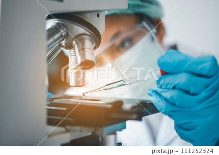 Female researchers are experimenting with pipette dropping a sample into a test tube in an experiment research in laboratory... Female researchers are experimenting with pipette dropping a sample into a test tube in an experiment research in laboratory... 111252324