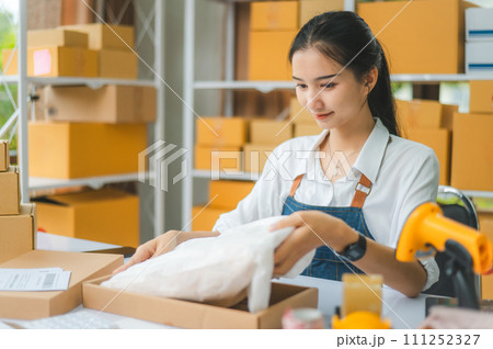 Online small business owners are packing their ordered products that customers order online into a box .concept of online shopping 111252327