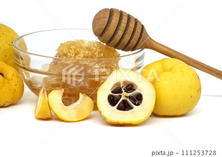 Vibrant quince fruits and bowl with honey on white Vibrant quince fruits and bowl with honey on white 111253728