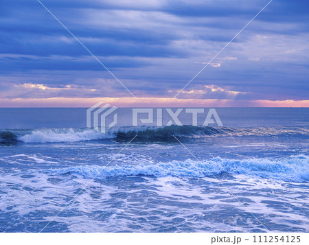 冬の朝の海岸 雲に覆われた空と波が打ち寄せる海岸 冬の朝の海岸 雲に覆われた空と波が打ち寄せる海岸 111254125