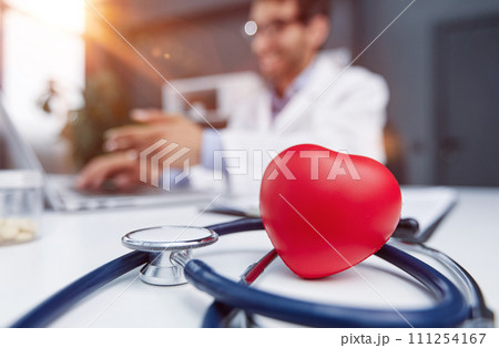 Stethoscope and red heart on wooden table. Cardiology concept Stethoscope and red heart on wooden table. Cardiology concept 111254167
