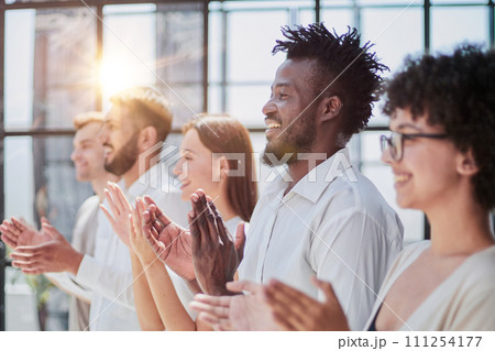 Group of businesspeople sitting in a line and applauding. Group of businesspeople sitting in a line and applauding. 111254177