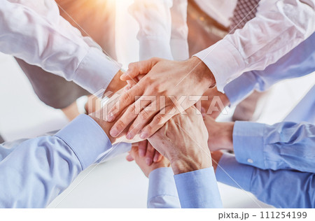 Top view shot of stack of hands. Young college students putting their hands on top of each other symbolizing unity and teamwork. 111254199