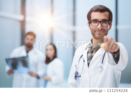 Young doctor man pointing with finger to the camera and to you, hand sign 111254226