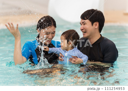 happy family. father and mother with small daughter in swimming pool. happy family. father and mother with small daughter in swimming pool. 111254953