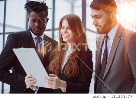 Colleagues Holding Files with Business Report and Reading it Together at Work Colleagues Holding Files with Business Report and Reading it Together at Work 111255377