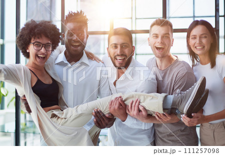 Business team throwing his colleague in office Business team throwing his colleague in office 111257098