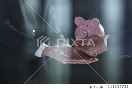 A businessman gives you a piggy bank isolated on a black background. A businessman gives you a piggy bank isolated on a black background. 111257731