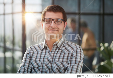 Charming handsome. Handsome young man in casual wear keeping arms crossed while standing 111257781