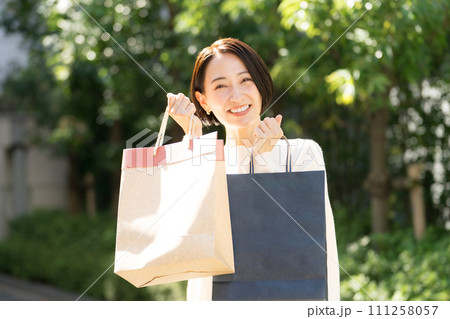 ショッピングバッグを両手に持つ女性 111258057