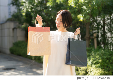 ショッピングバッグを持つ困り顔の女性 ショッピングバッグを持つ困り顔の女性 111258240