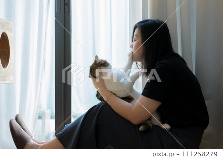 wellness and wellbeing concept with asian woman sit and play with her cat in livingroom wellness and wellbeing concept with asian woman sit and play with her cat in livingroom 111258279