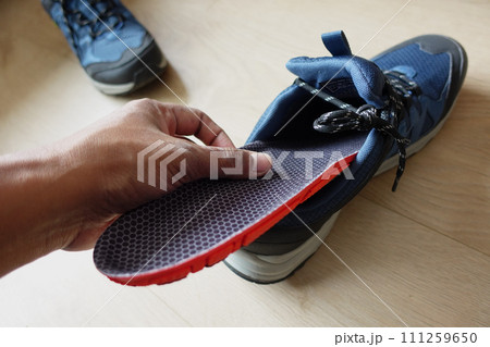 men hand putting Orthopedic insoles in shoes men hand putting Orthopedic insoles in shoes 111259650