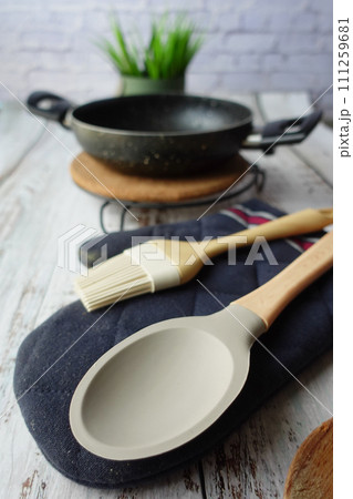 wooden cutlery fork and spoon and cooking pan on table wooden cutlery fork and spoon and cooking pan on table 111259681