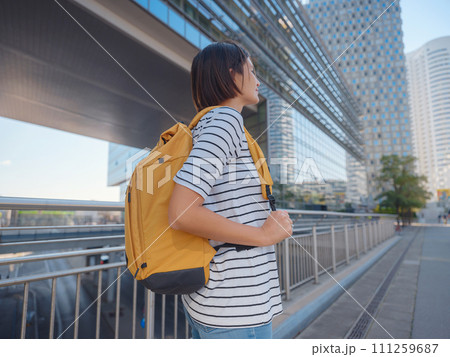 Female tourist traveling in Austria, capital city Vienna. summer female solo trip to Europe, happy young woman walking in Donaustadt district street 111259687