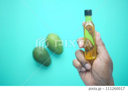 holding a bottle of avocado oil holding a bottle of avocado oil 111260017