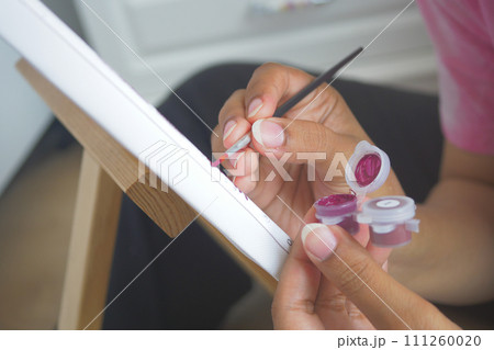 women hand holding brush with paint women hand holding brush with paint 111260020