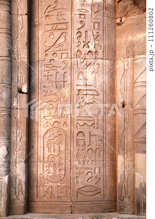 Ancient Egyptian hieroglyphs on stone wall, Com Ombo Temple of gods Horus and crocodile-headed Sobek, Egypt, North Africa.  Com-Ombo Temple wall and columns with carvings hieroglyphs 111260802
