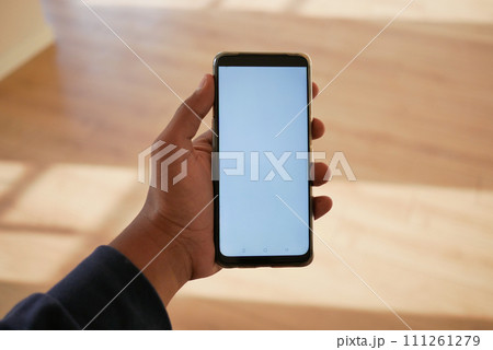 pov shot of hand using phone showing empty screen in empty room 111261279