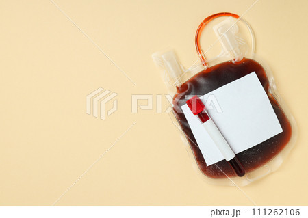 Bag and test tube with donor blood on beige background, space for text Bag and test tube with donor blood on beige background, space for text 111262106