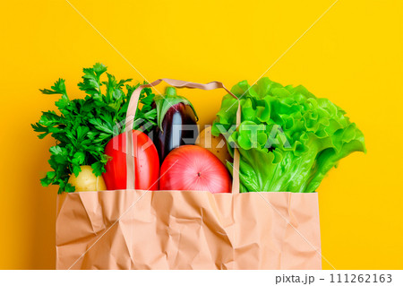 Craft brown shopping paper bag and grocery on blue background. Delivery concept Craft brown shopping paper bag and grocery on blue background. Delivery concept 111262163