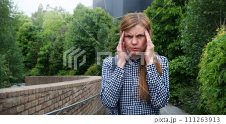 Girl with a headache on the street Girl with a headache on the street 111263913