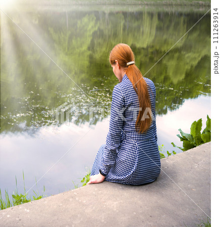 Pretty girl sitting at the lake Pretty girl sitting at the lake 111263914