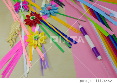 Workplace with elements for creating paper art using the quilling technique. Hobby tools and details with paper Workplace with elements for creating paper art using the quilling technique. Hobby tools and details with paper 111264321