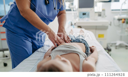 Close up of doctor palpating girl's abdomen, hands and steady pressure on belly. Concept of preventive health care for children. Close up of doctor palpating girl's abdomen, hands and steady pressure on belly. Concept of preventive health care for children. 111264928